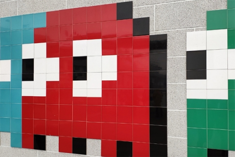 Blue, red, and green pacman ghosts on a tile wall