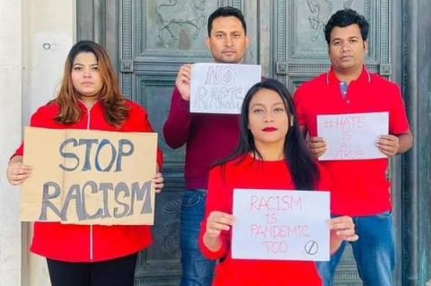4 students stood in front of the Guildhall showing Racism the Red Card