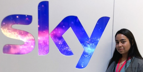 Mary standing next 'Sky' logo