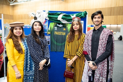 Students posing in front of the flag of Pakistan