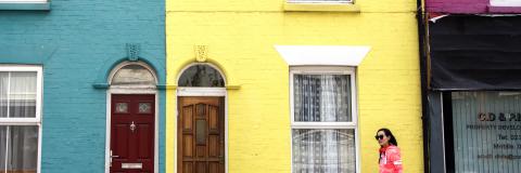Student walking down Southsea street past colouful houses