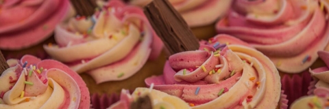 Close up photograph of pink cupcakes with chocolate flakes