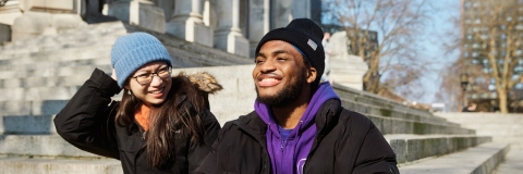 Two students sat on outdoor steps