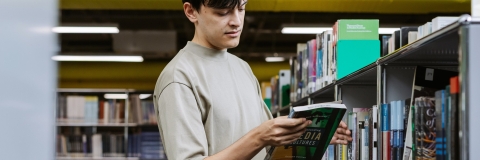 Student reading a book in the University Library 