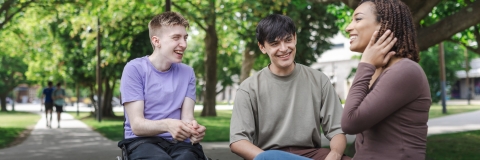 Three students laughing and talking