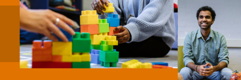 Adults play with colorful building blocks on the floor; one sits smiling separately, observing the activity.