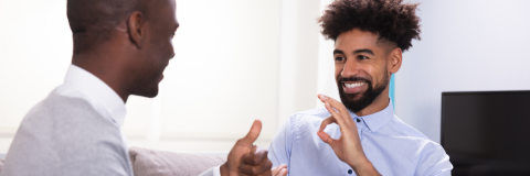 Two people dressed professionally and having a conversation in sign language