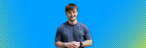 A man smiling against a bright blue background