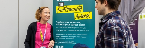 Careers adviser speaking to a student at en events stand