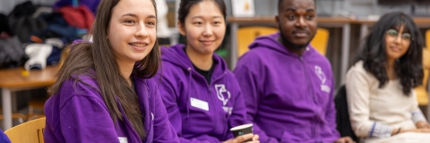 Students sitting together in purple university hoodies