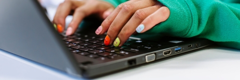 Hands typing on laptop