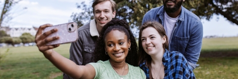 Smiling students taking selfie at Southsea Common