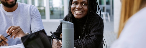 Three students working together with Laptop and Books in Eldon seating area
