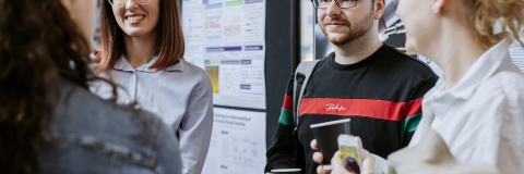 Group photo of PGR students talking inside building.