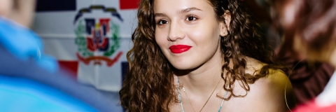 Female student smiling and talking to others at Festival of Cultures