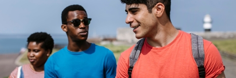 Group of friends walking together on a beach on a sunny day