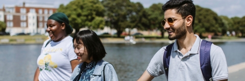 Three students walking by Canoe Lake in Southsea