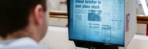 student looking at the new on a computer