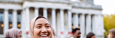 International students smiling and laughing outside Portsmouth Guildhall
