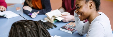 Students in library smiling in group study