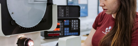 Female student operating cutting bench.Technology Facilities Day One - NOT FOR THIRD PARTY - CONSENT