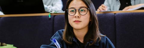 Female student taking notes in lecture