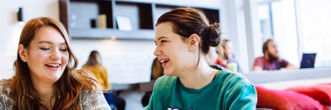 Male and female students studying in University library