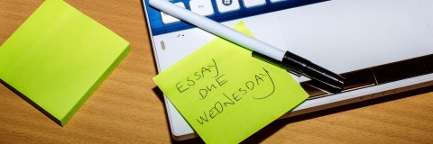 Laptop open with sticky notes showing essay deadlines