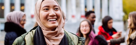International students smiling and laughing outside Portsmouth Guildhall