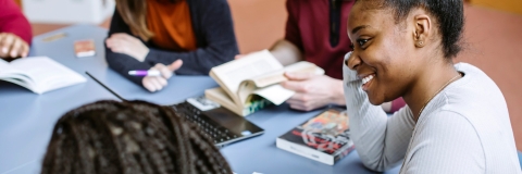 Students in library smiling in group study