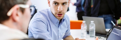 Man talking to another man over papers