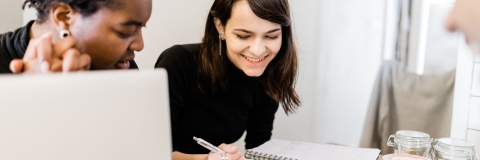 students smiling over coffee at a desk