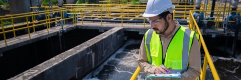 Engineer take water from wastewater treatment pond to check the quality of the water. After going through the wastewater treatment process.
