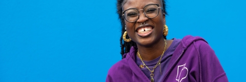 Ambassador laughing stood against blue background