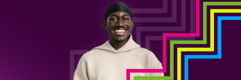 A student smiling in front of a purple background