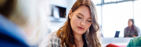 Female student in blazer reading notes