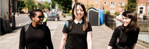 Smiling students walking down street in sun