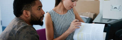 Male and female look over notes in laboratory