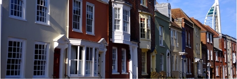 Row of coloured houses on street with the spinnaker tower just visible in the backgroun