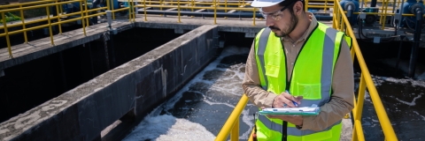 Engineer take water from  wastewater treatment pond to check the quality of the water. After going through the wastewater treatment process.