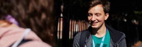 Student with a lanyard on outside University Library