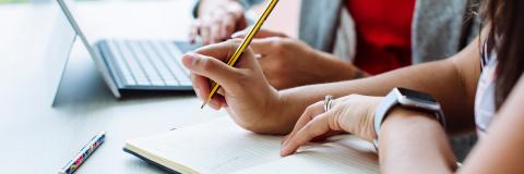 Postgrad students taking notes and planning essay