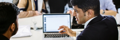 Man working with a colleague at a laptop