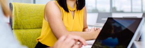 Student sat in chair smiling at another person