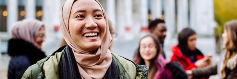 International students smiling and laughing outside Portsmouth Guildhall