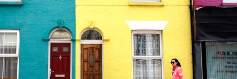 Student walking down Southsea street past colouful houses