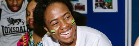 Student smiling, she has Tanzanian flags painted on her cheeks