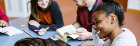 Students in library smiling in group study