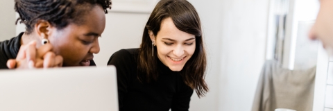 students smiling over coffee at a desk