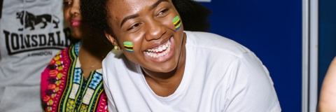 Student smiling, she has Tanzanian flags painted on her cheeks